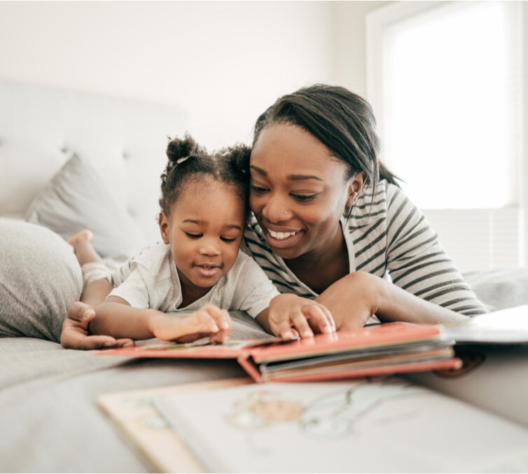 Bright Beginnings - image of a parent and young child smiling while reading a book