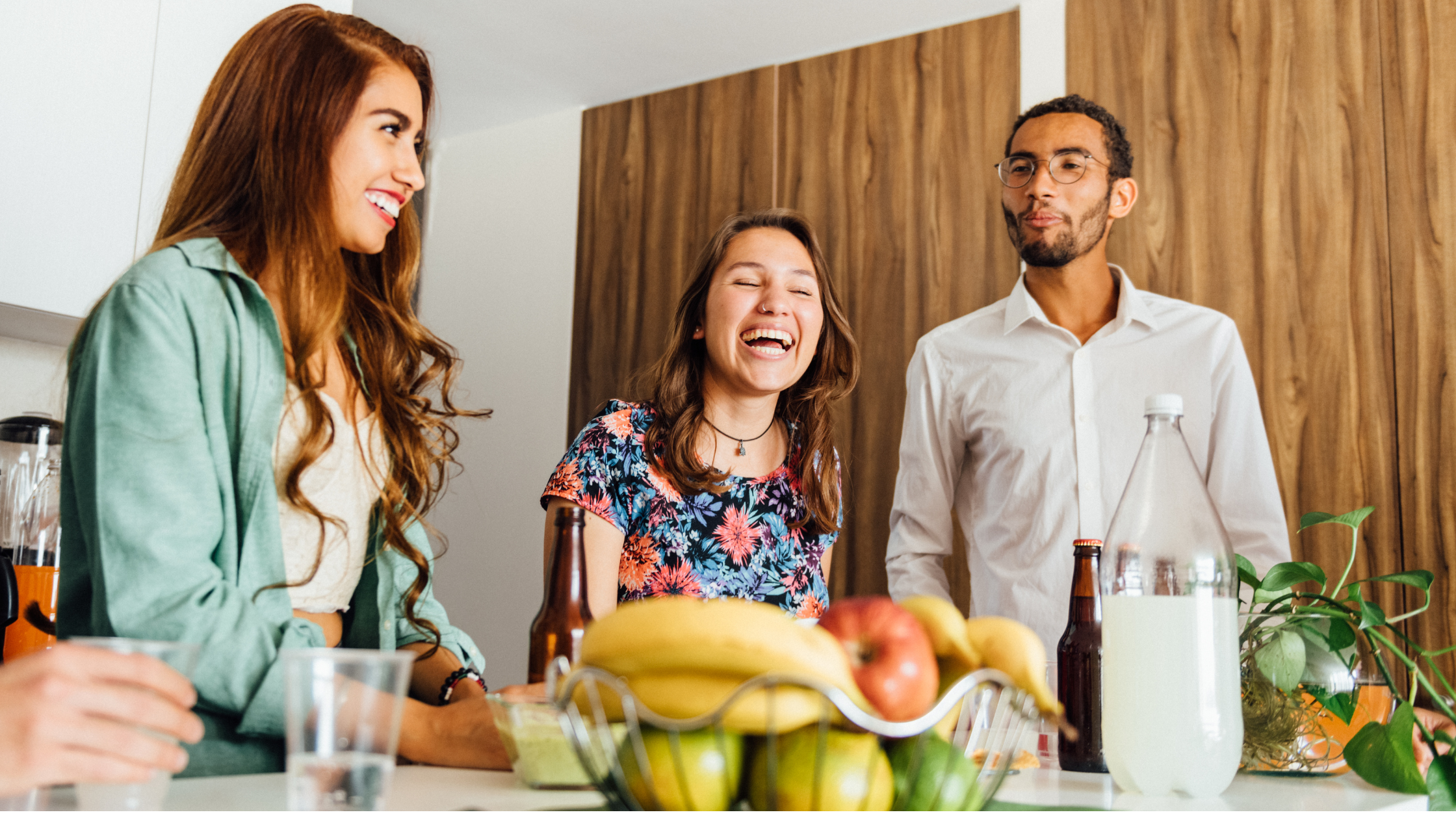 three friends laughing in kitchen housewarming party