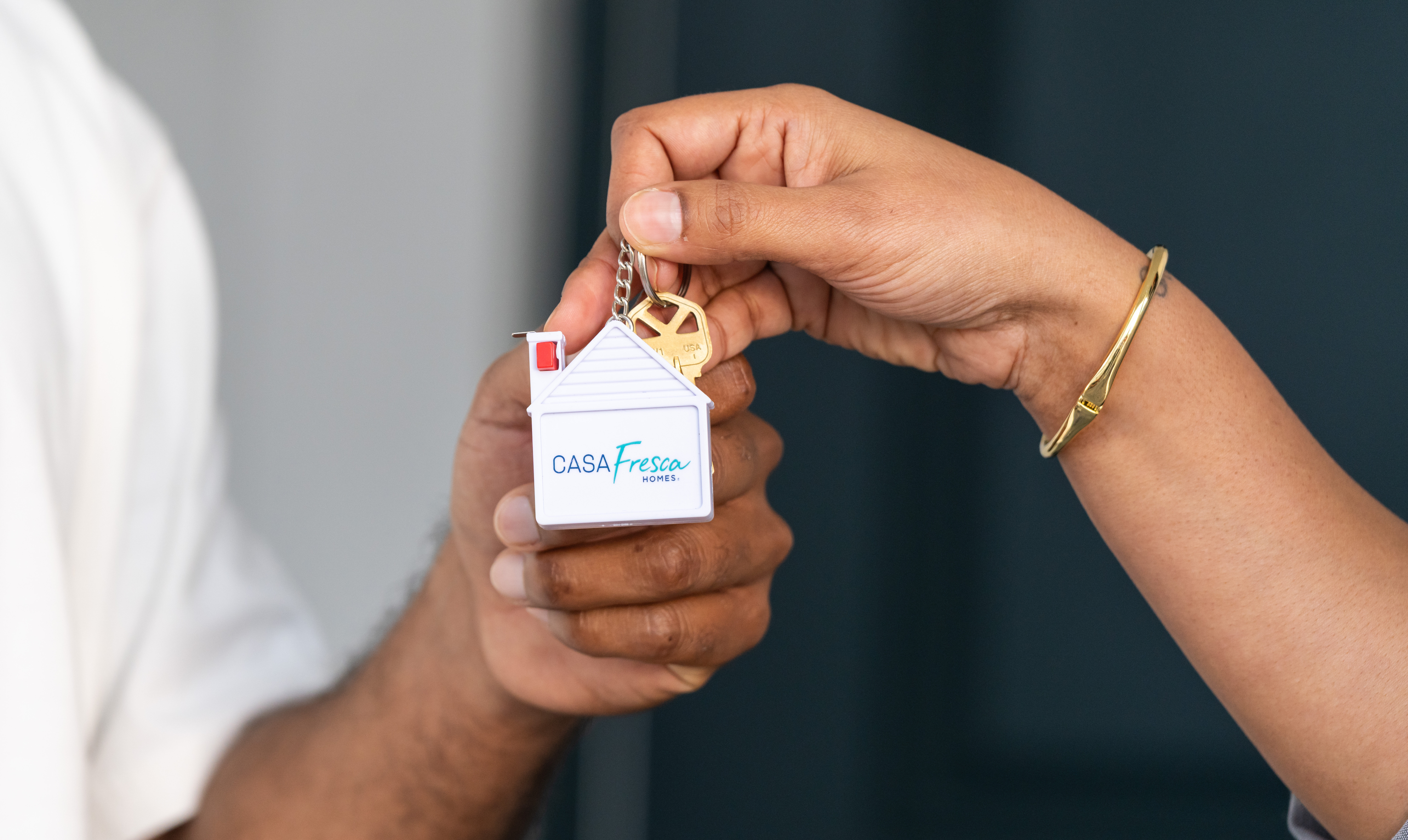 Homebuyer receiving house keys with a Casa Fresca keychain after choosing from mortgage options for new home buyers